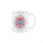 a white ceramic mug with the King Charles official emblem for the coronation