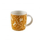 a mustard coloured china mug with a woodland inspired print