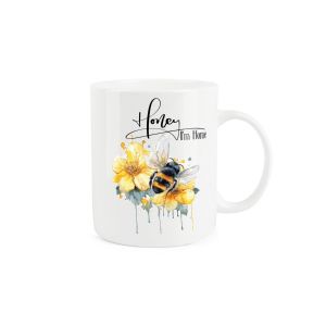 White bone china mug featuring a sweet illustration of a bee resting on yellow flowers, with the caption "Honey I'm Home".