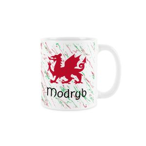 White ceramic mug with a red welsh dragon,splattered red and green background and modryb (auntie) text