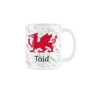 White ceramic mug with a red welsh dragon,splattered red and green background and taid (grandad) text